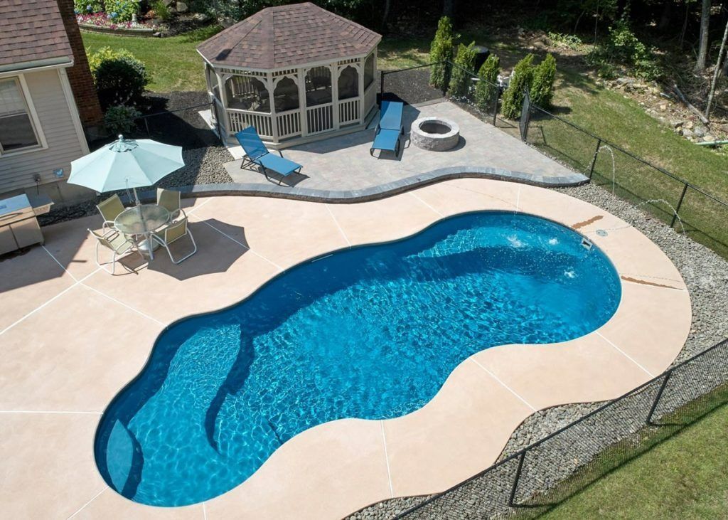 An aerial view of a blue, kidney-shaped swimming pool in a backyard with a gazebo, patio furniture, and a fire pit.