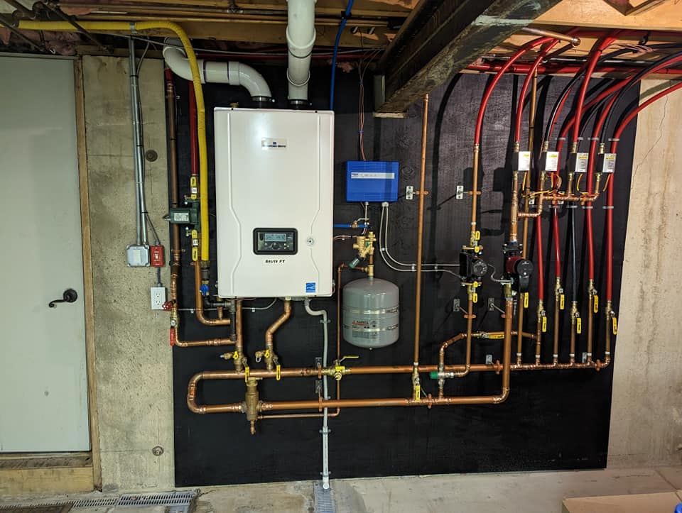 A boiler is mounted to a wall surrounded by pipes.