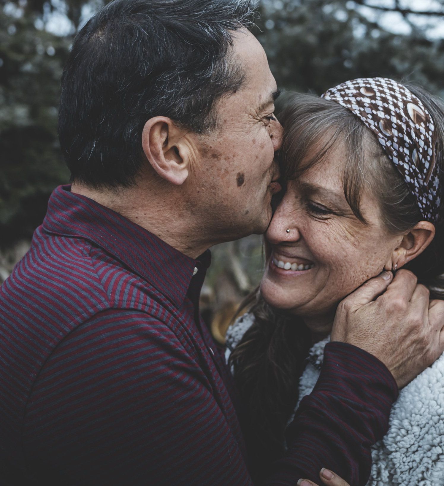 A man is kissing a woman on the cheek.