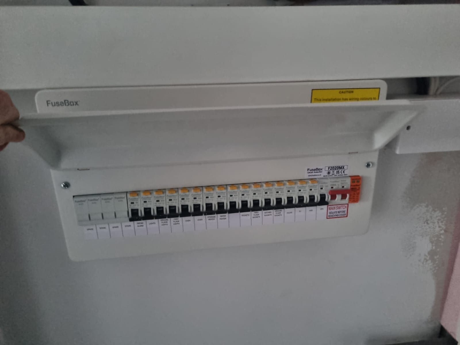 A man is kneeling down in a room working on a pipe.