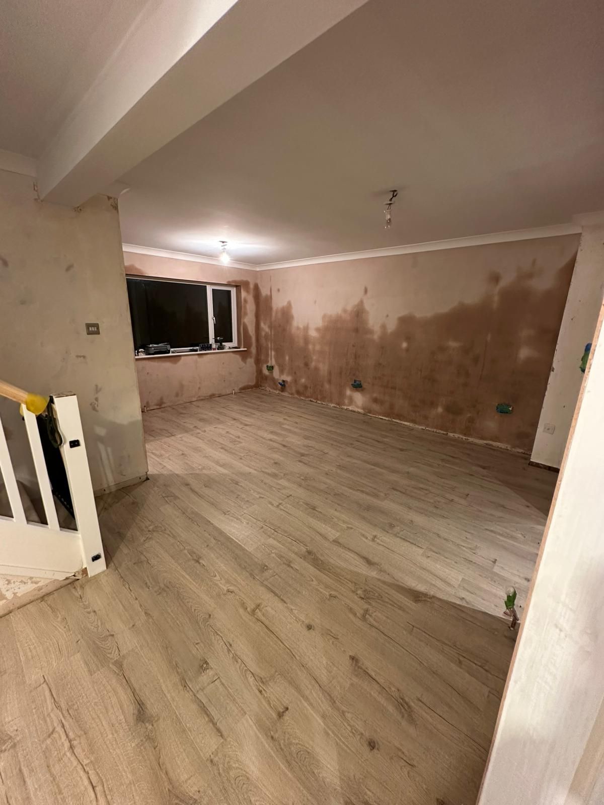 A man is working on a wall in a room.