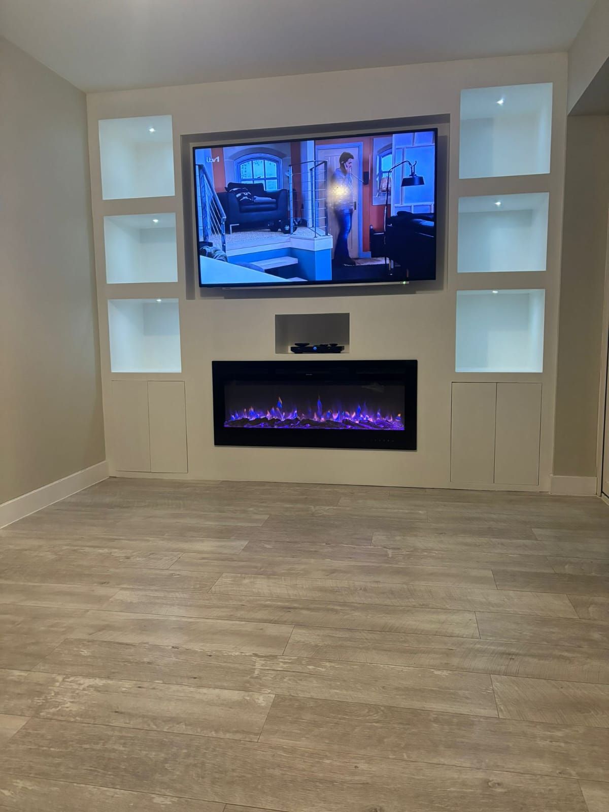 A group of people are sitting around a table looking at a blueprint.