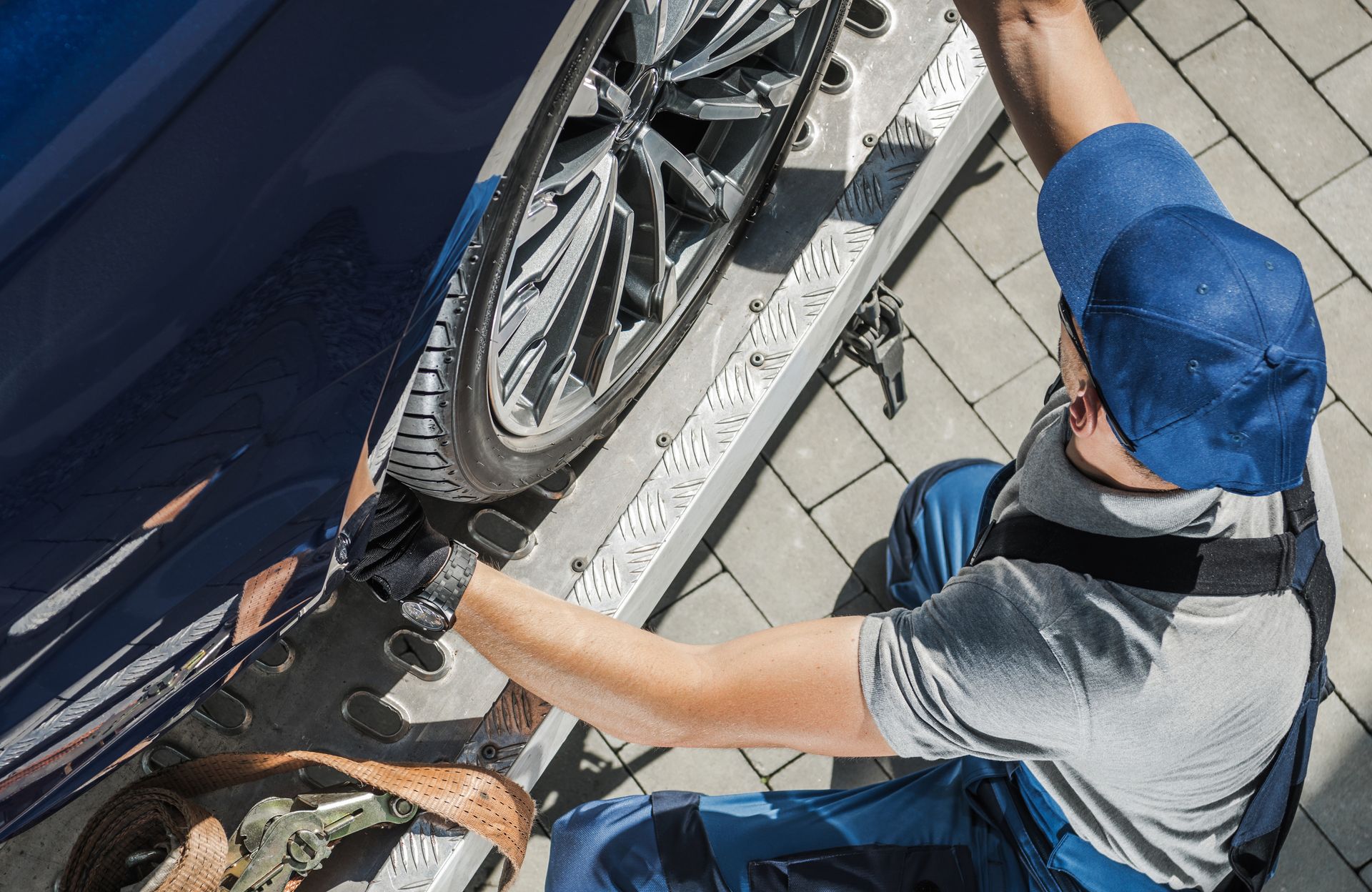 A man is working on the wheels of a car.