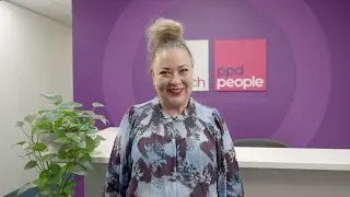 Woman in front of a reception desk with a logo for 