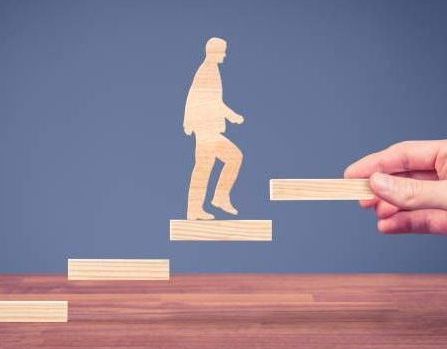 Person using a stylus on a glowing tablet screen at night, city lights blurred in background.