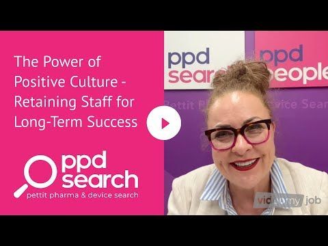 Woman with glasses in front of a pink background, discussing staff retention and positive company culture.
