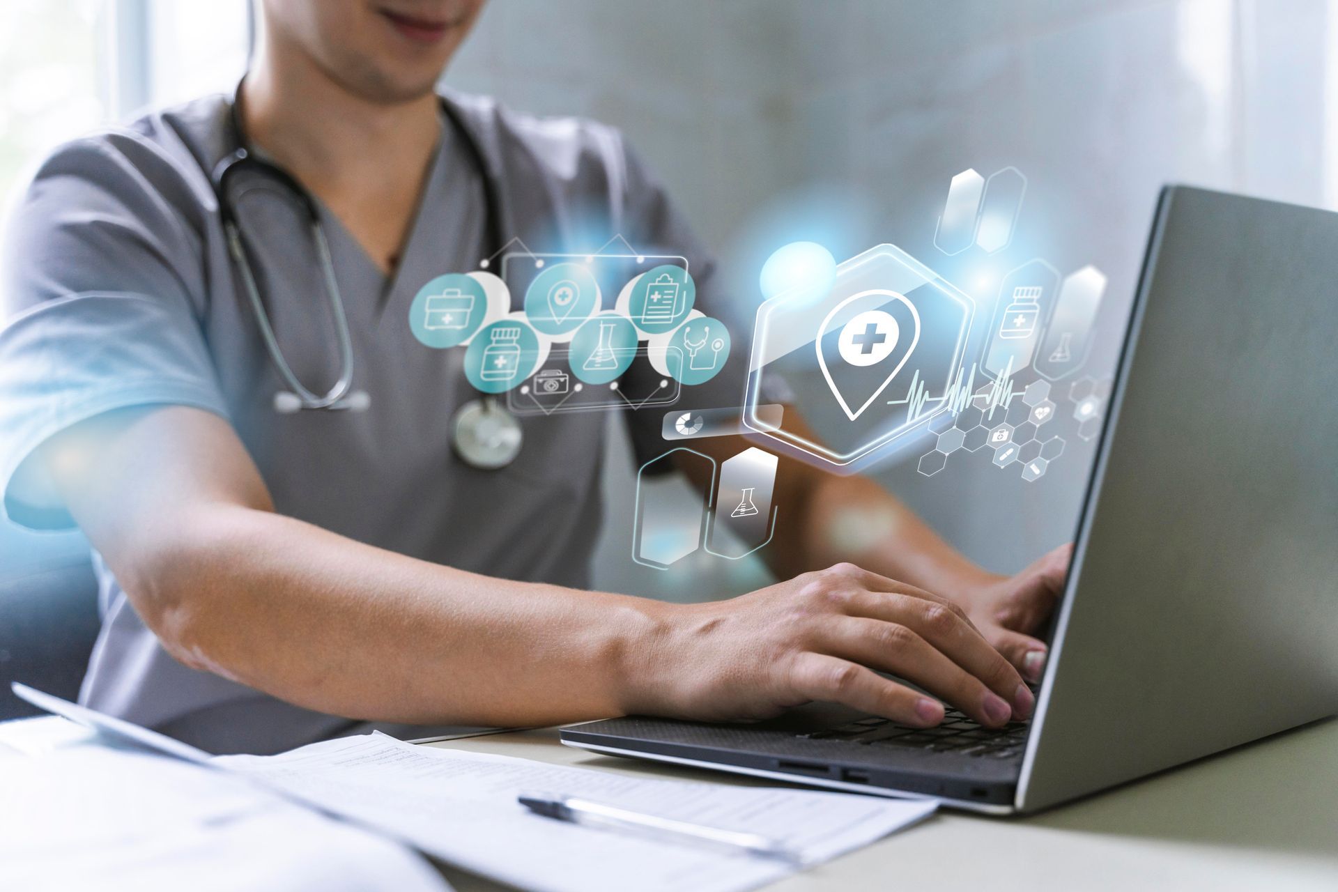 Medical professional in gray scrubs using laptop, with digital health icons floating above.