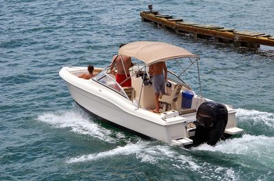 White runabout motorboat with a canvas Bimini top