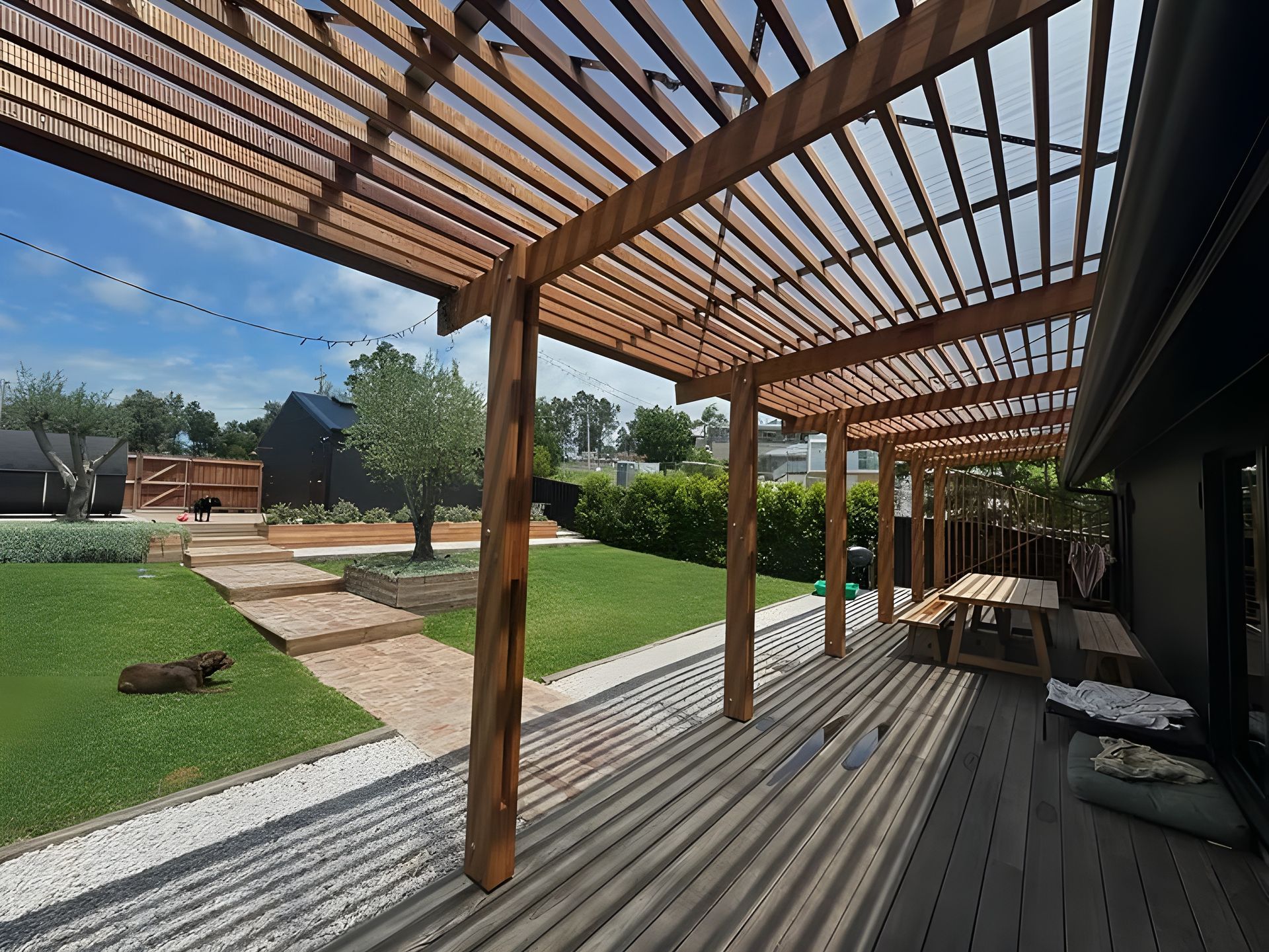 Wooden Pergola Over a Deck and Lawn With a Dining Table — Envisage Construction and Design in Jervis Bay, NSW