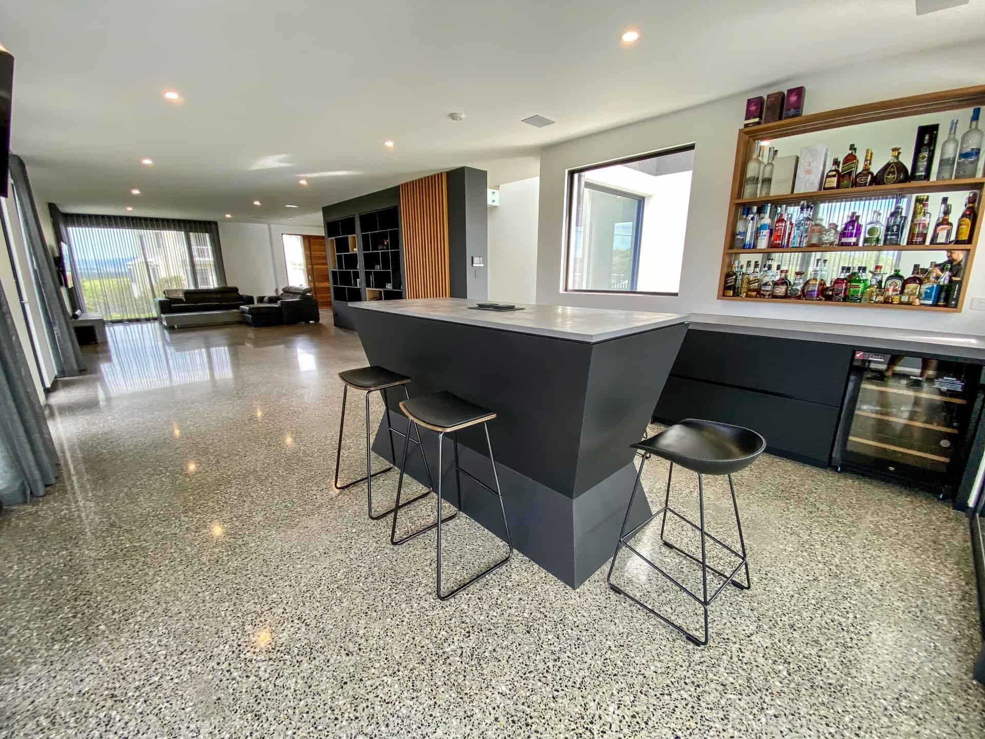 Modern Black Bar With Stools in a Spacious Room — Envisage Construction and Design in Anzac Way, NSW