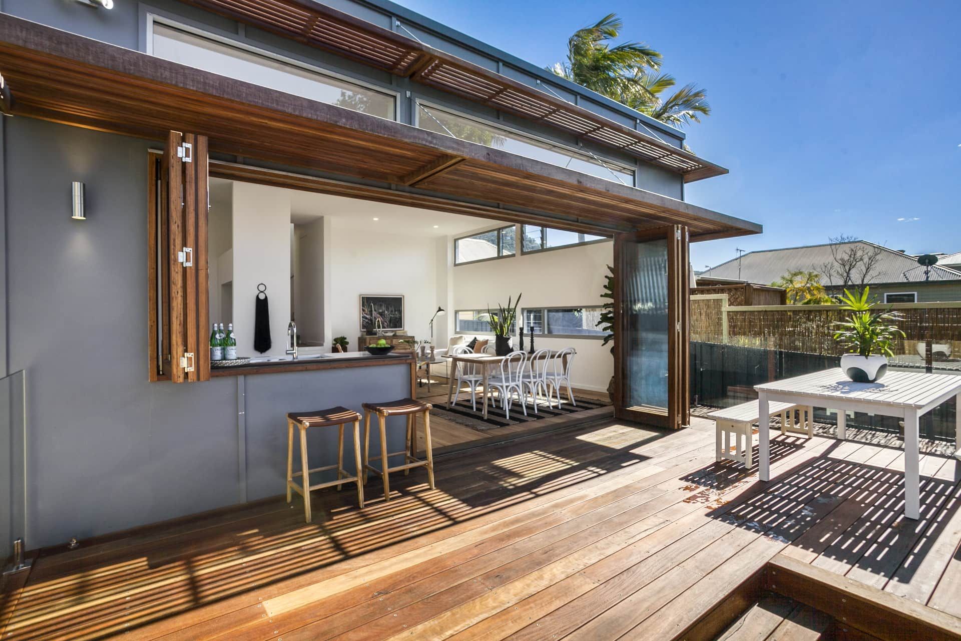 Wooden Deck With Open Doors Leading to an Interior Dining Area — Envisage Construction and Design in Keiraville, NSW