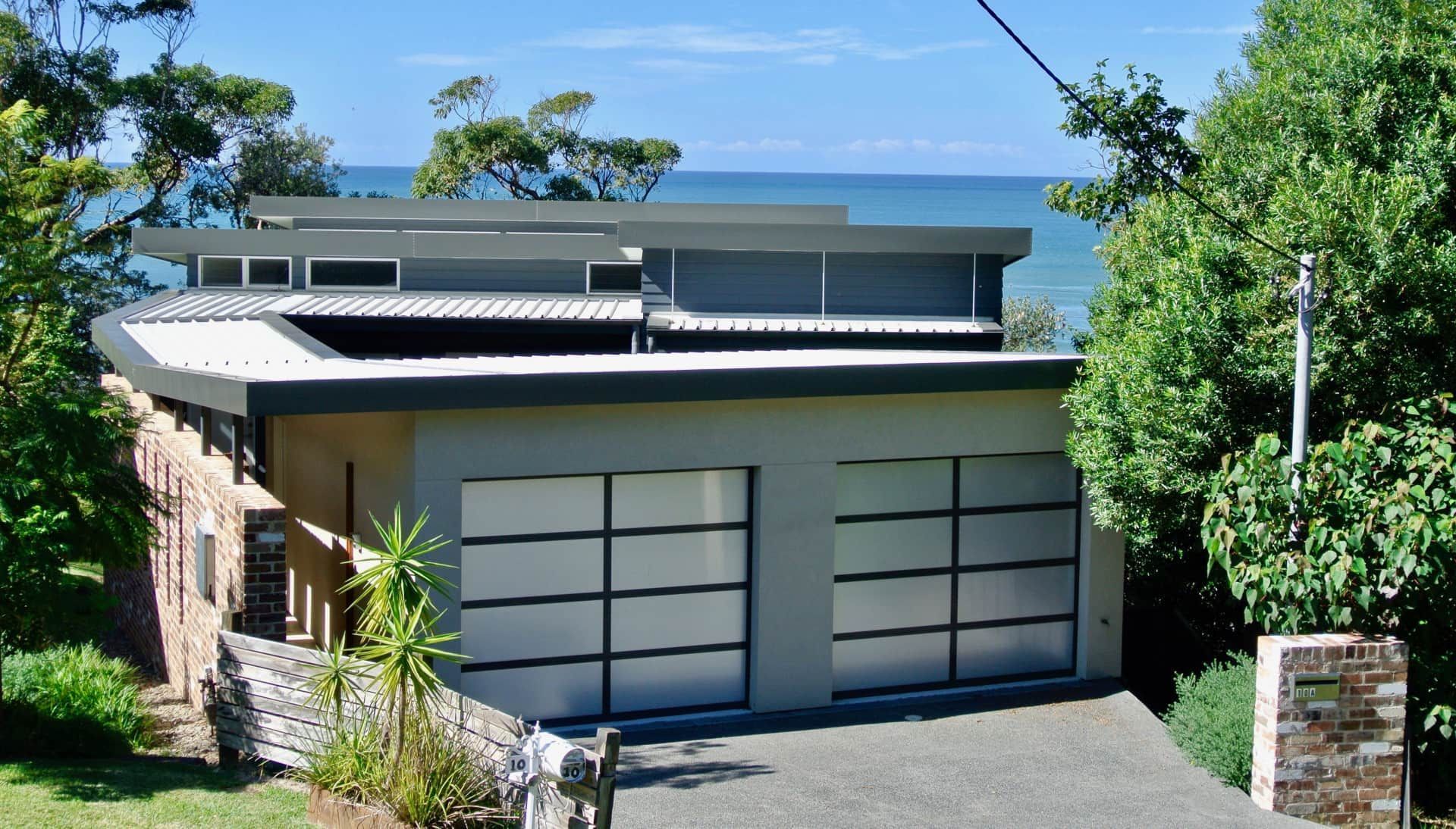 Modern House With Gray Roof and Garage Doors Overlooking the Ocean — Envisage Construction and Design in Coledale, NS