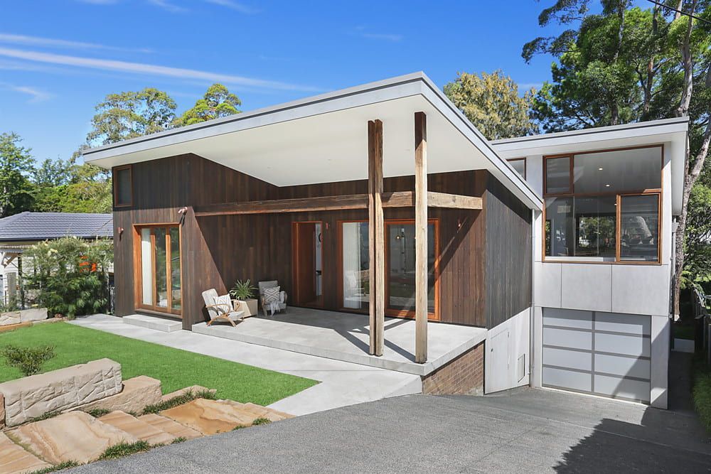 Modern home with dark wood siding, covered porch, and garage — Envisage Construction and Design in Mountain, NSW