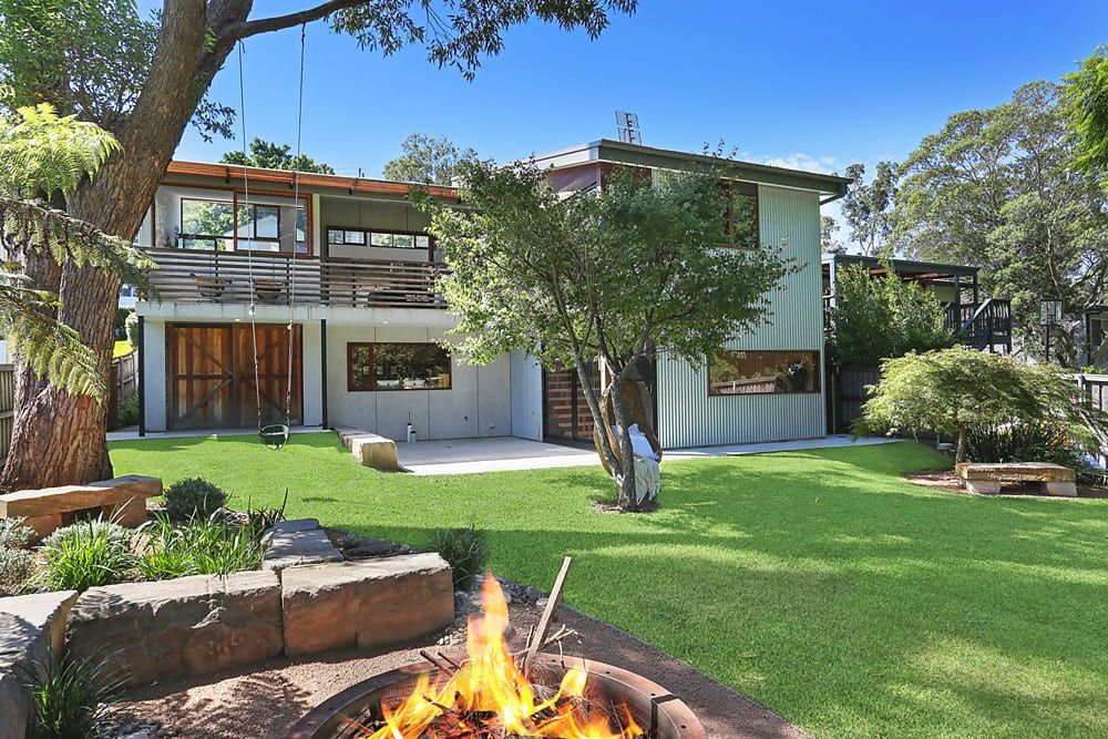 Fire Pit in Front of a Two-story House With a Green Lawn — Envisage Construction and Design in Koloona Dr, NSW
