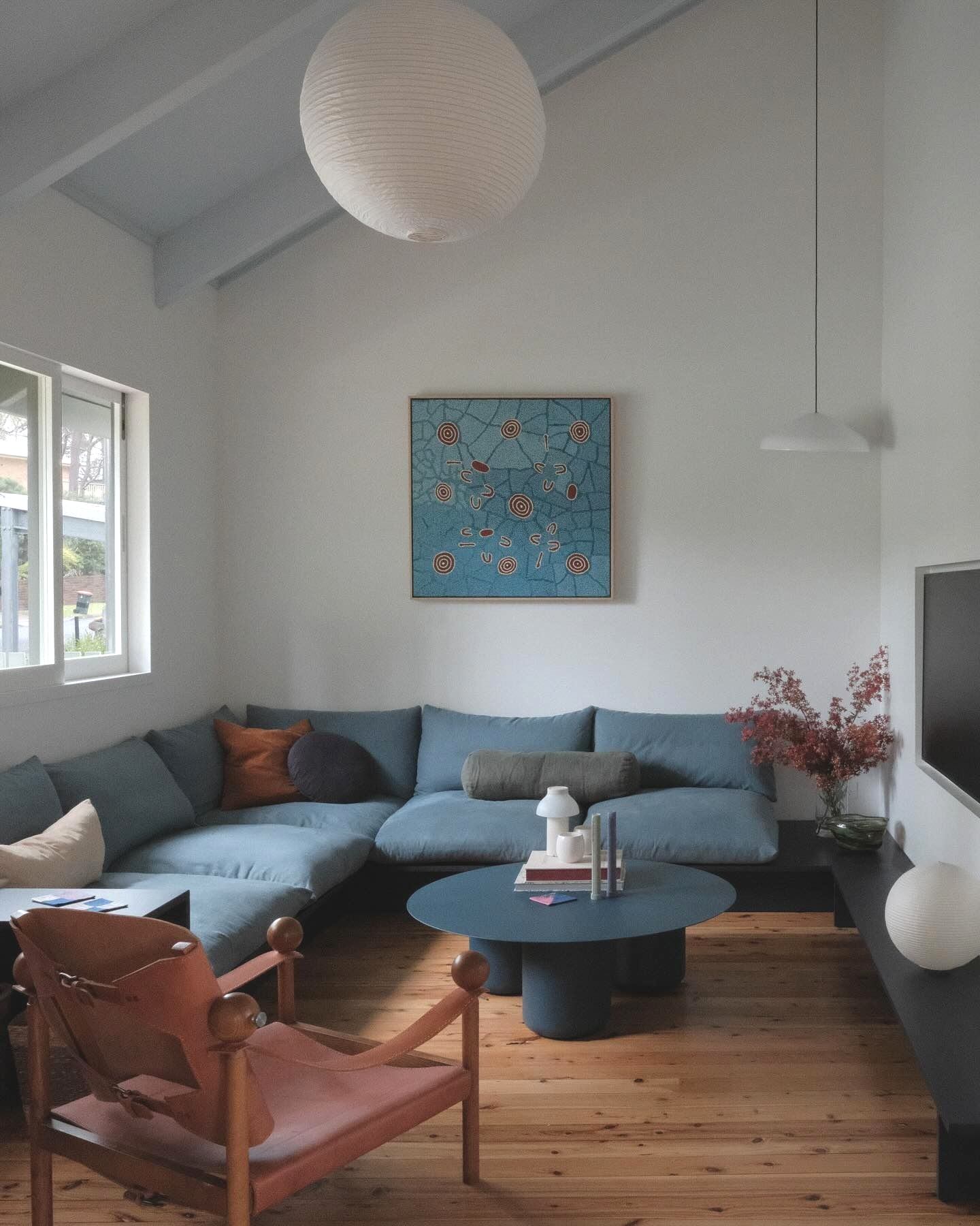 Living Room With Blue Sectional, Wooden Floors, Artwork — Envisage Construction and Design in Mountain, NSW