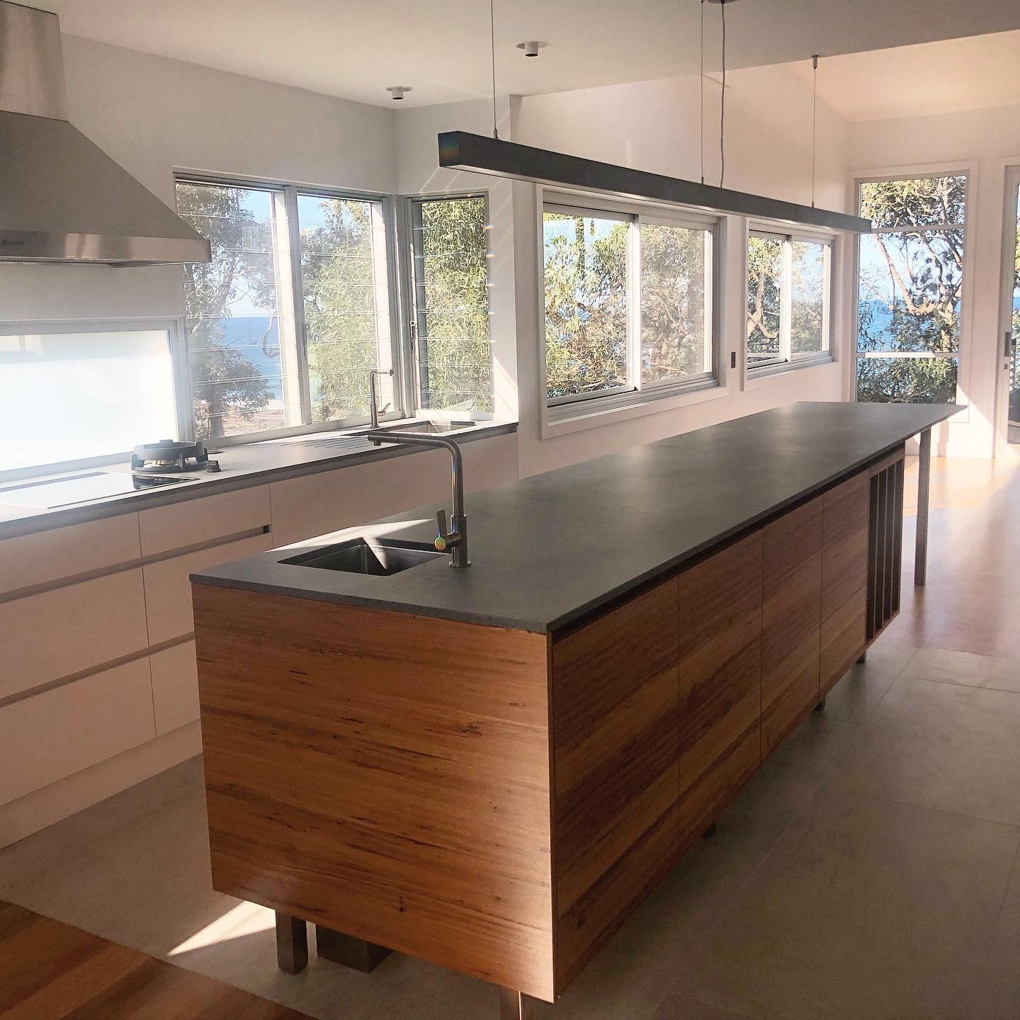 Modern Kitchen With Wood Island, Stainless Steel Appliances — Envisage Construction and Design in Mollymook, NSW