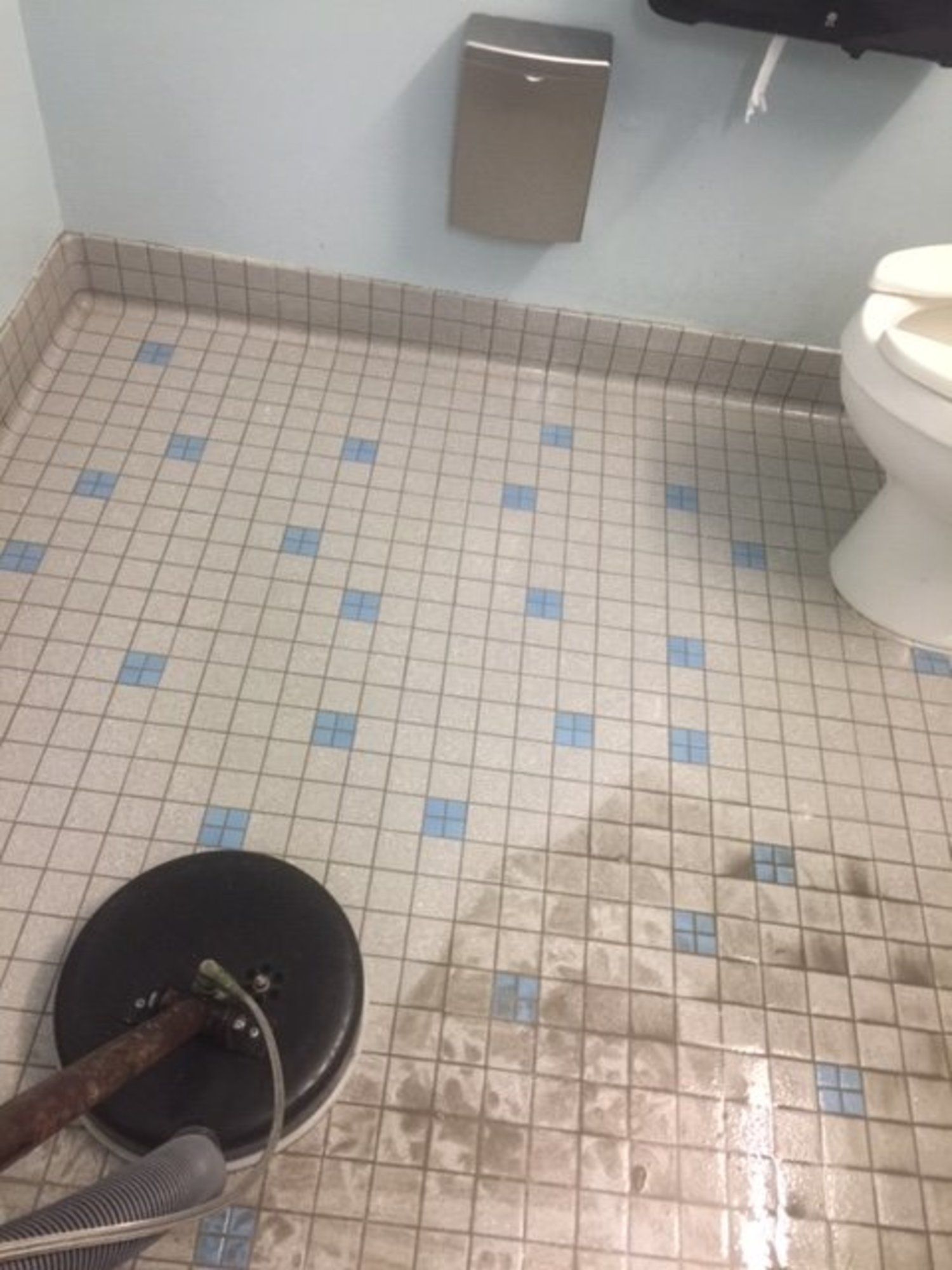 A bathroom with a tiled floor and a toilet.