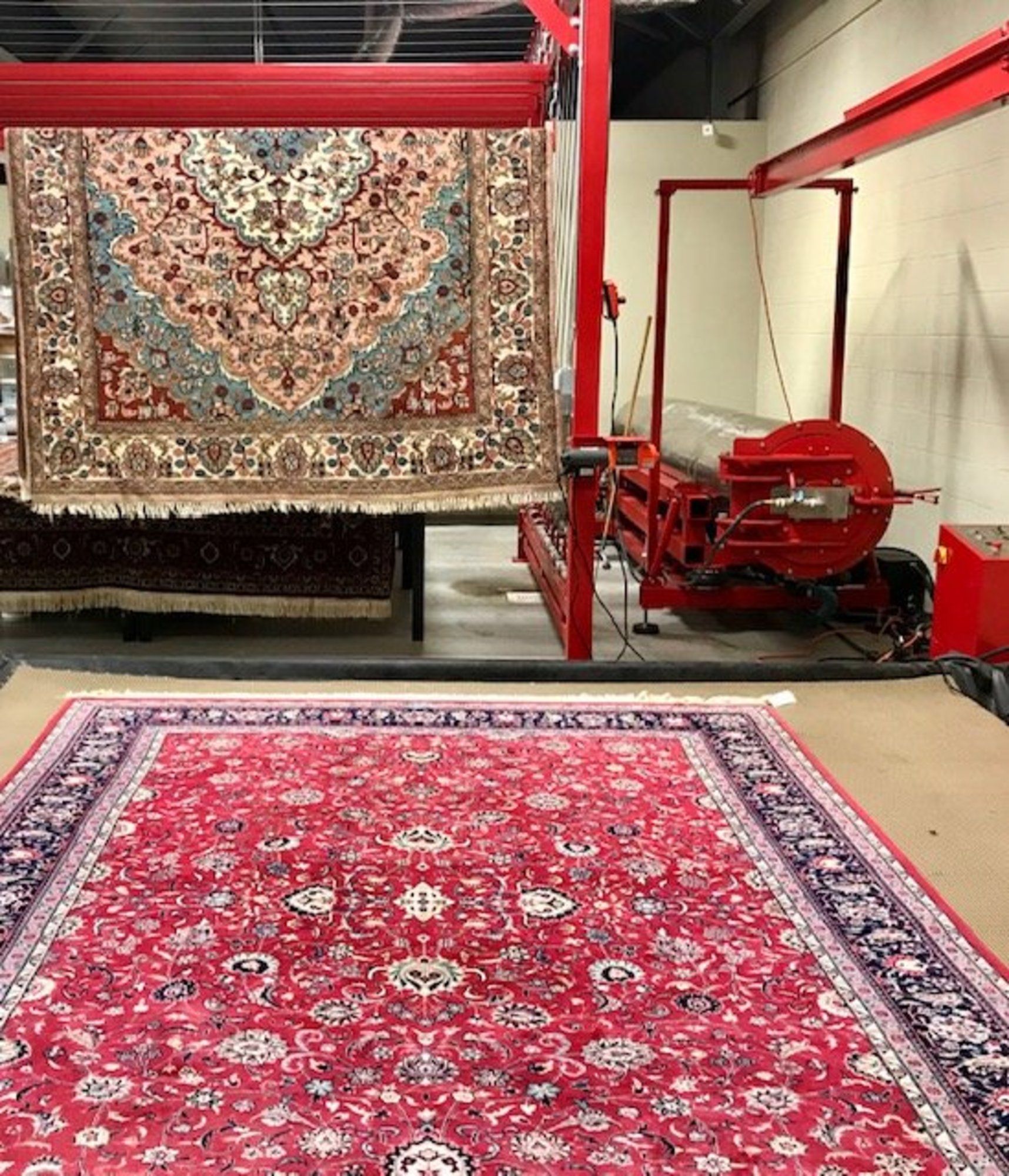 A red rug is sitting in a room next to a machine.