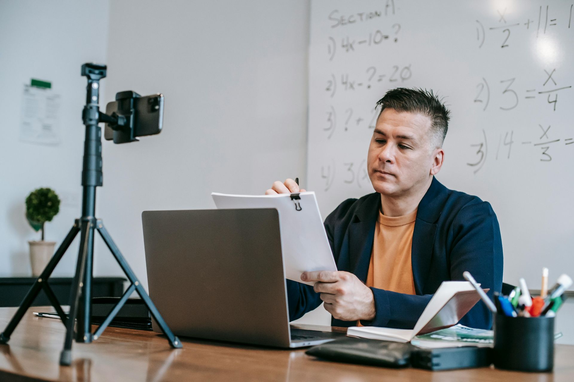 A man is sitting at a desk in front of a laptop computer.