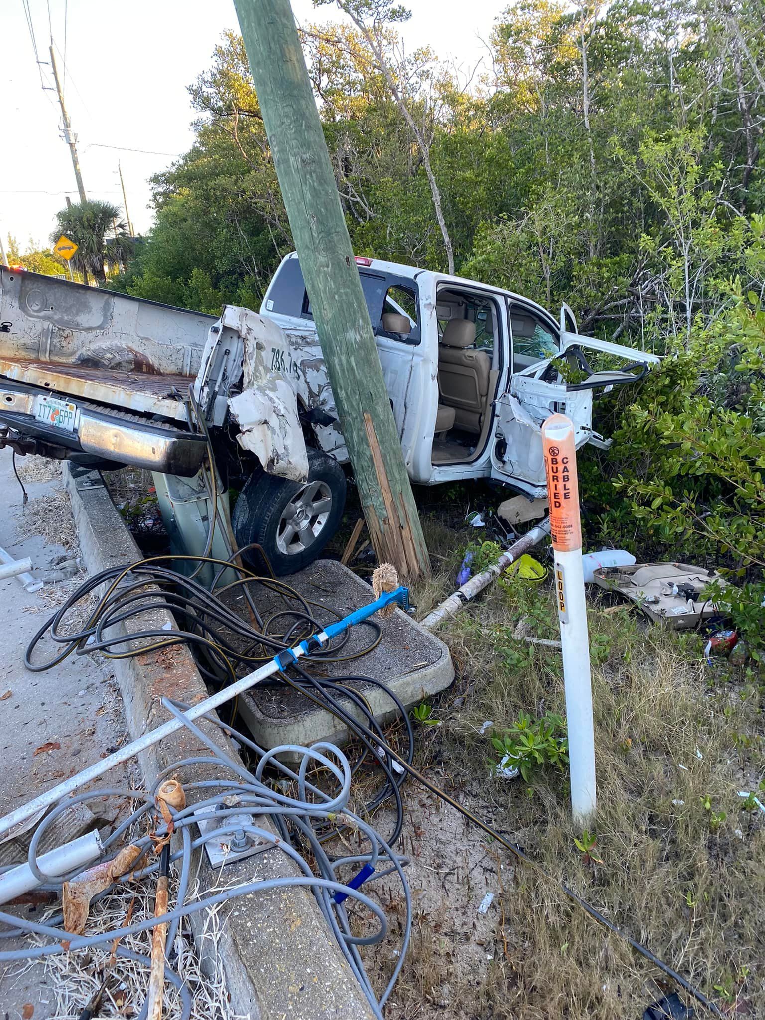 A truck has crashed into a power pole on the side of the road.