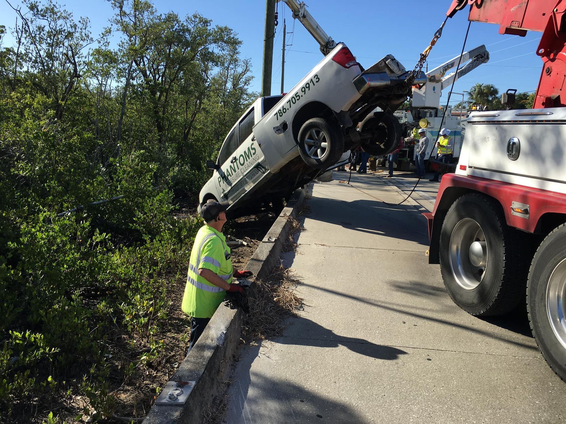 A white truck is being towed by a tow truck.