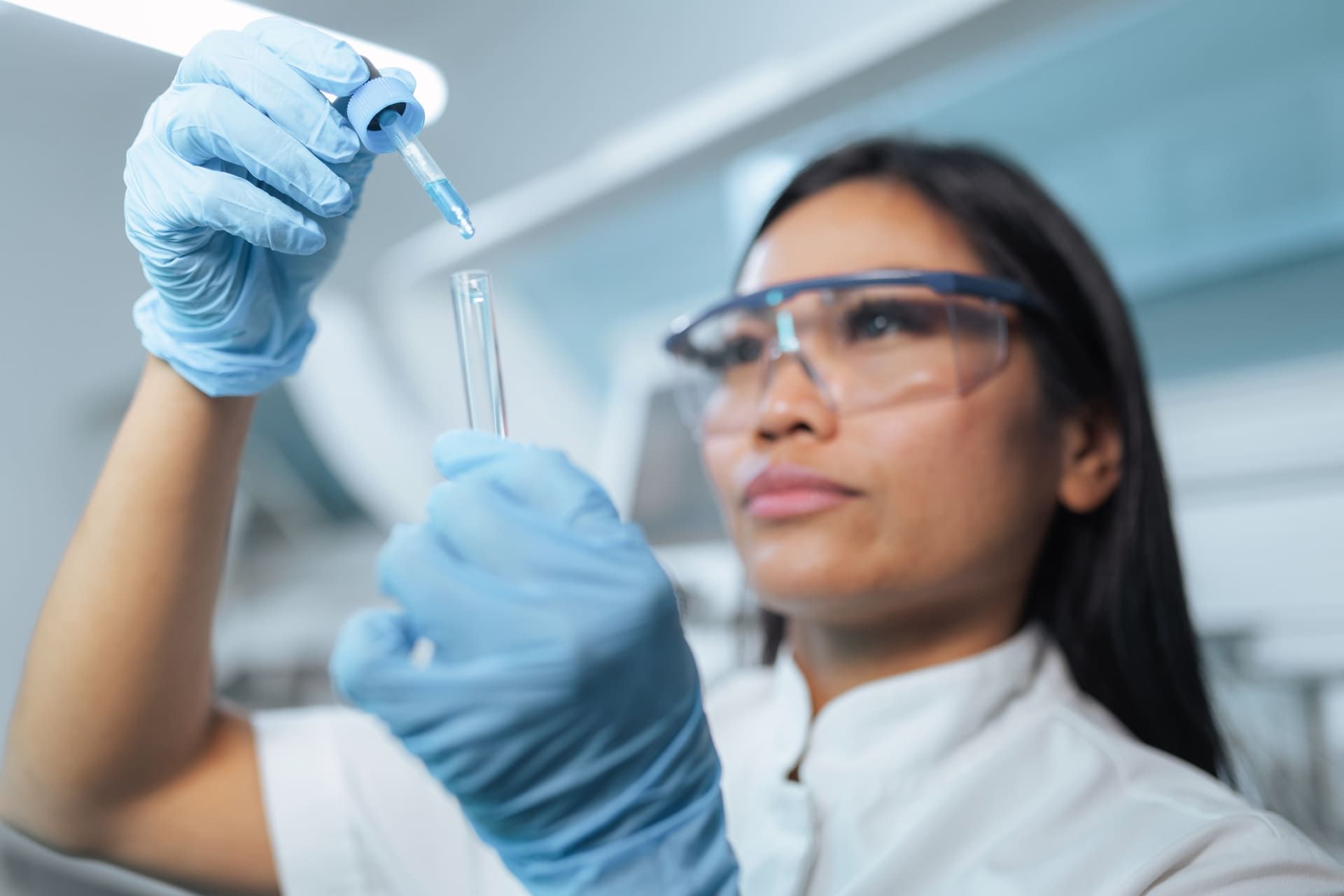 A professional Asian female scientist is working in a modern laboratory, conducting tests and analyzing samples with precision
