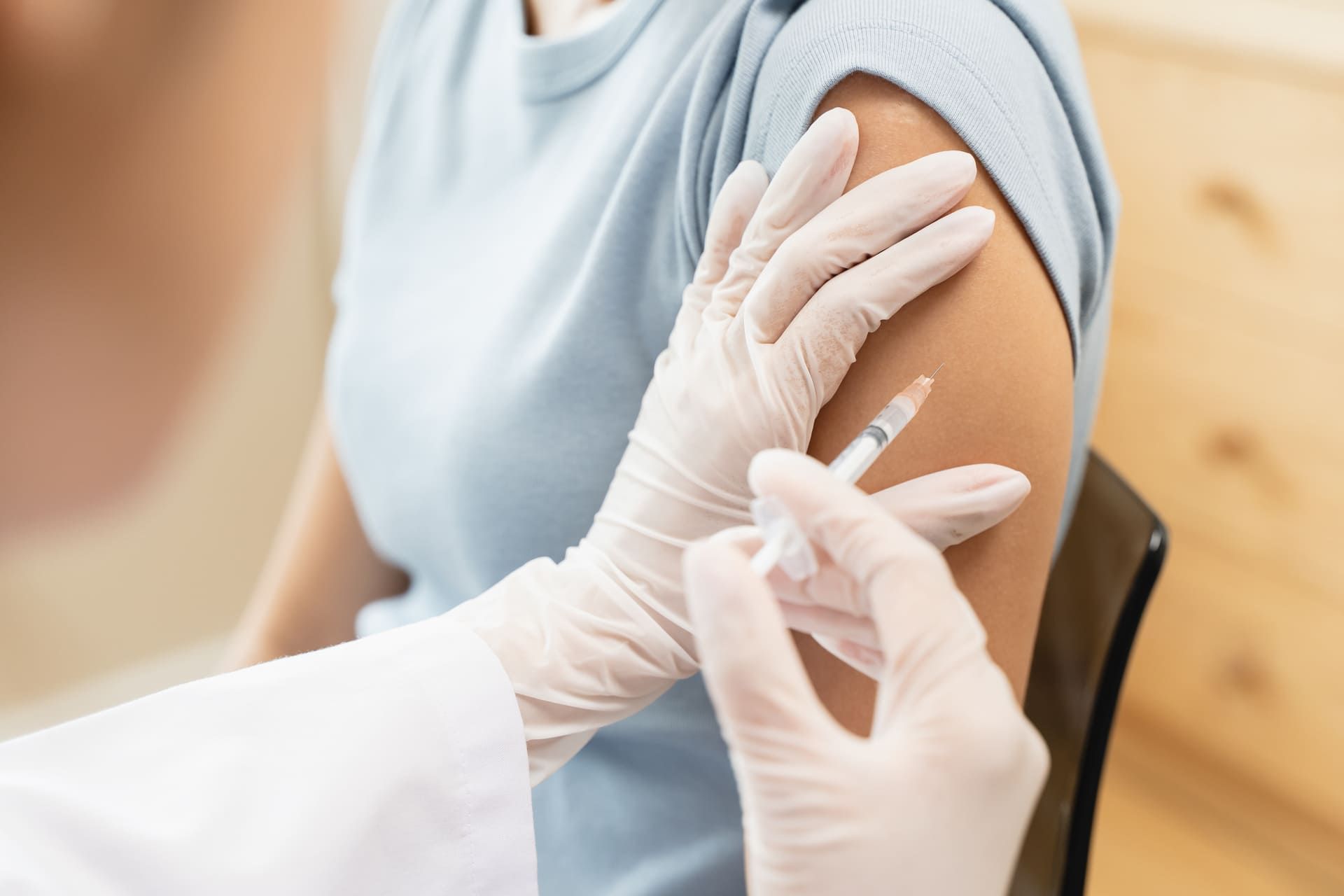 People getting a vaccination to prevent pandemic concept. Woman in medical face mask receiving a dose of immunization coronavirus vaccine from a nurse at the medical center hospital