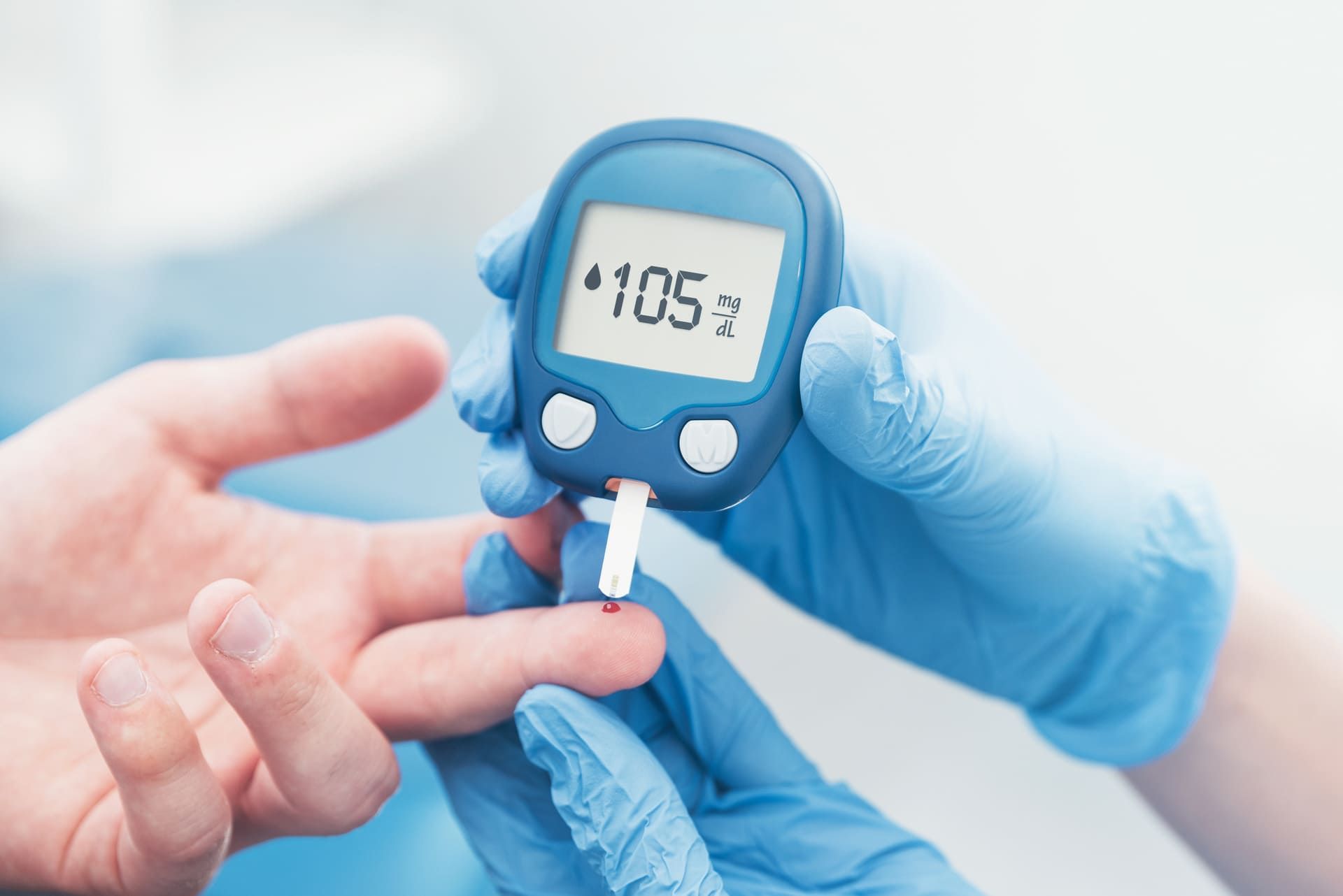 Doctor checking blood sugar level with glucometer