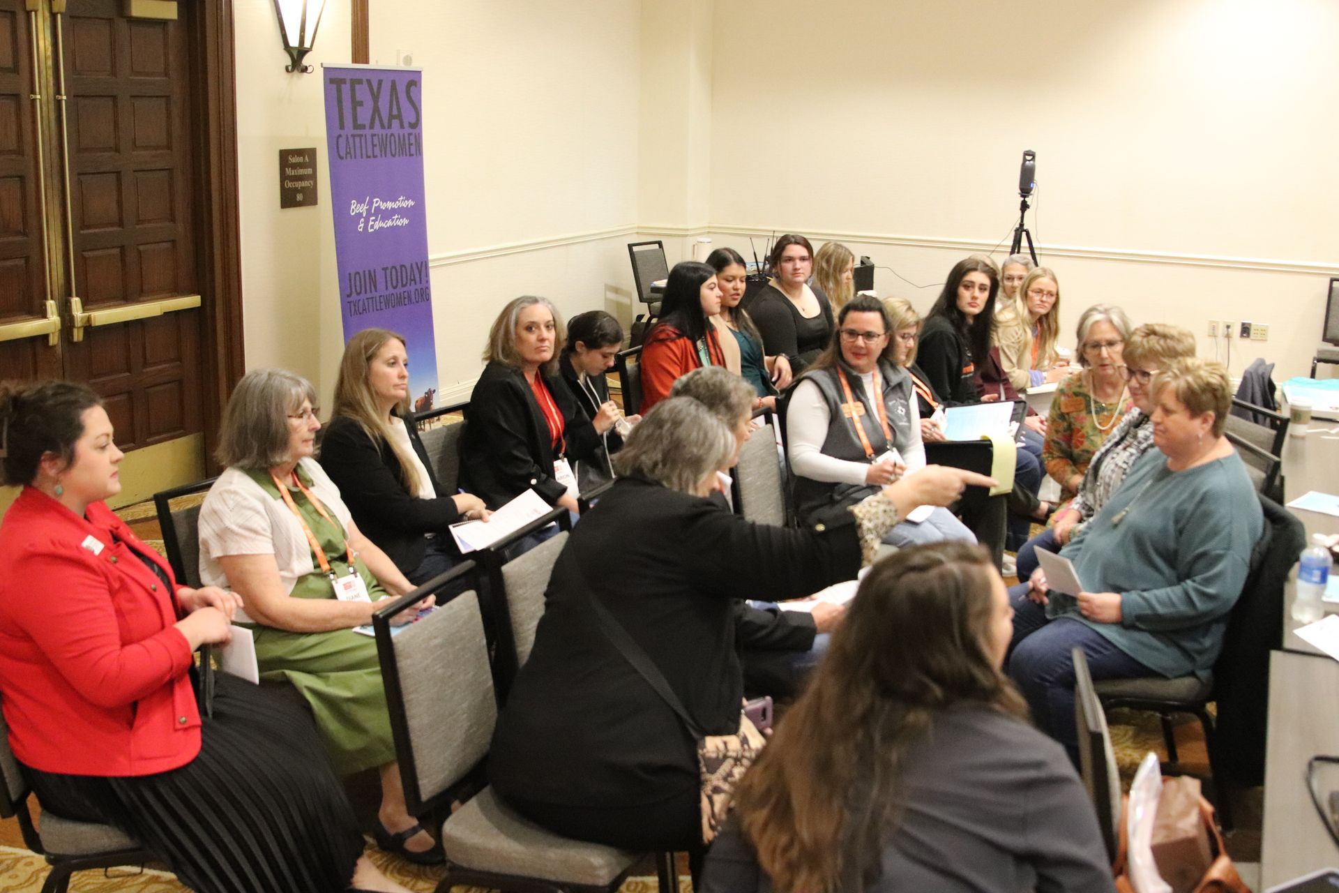 Five women smiling, posing behind illuminated 