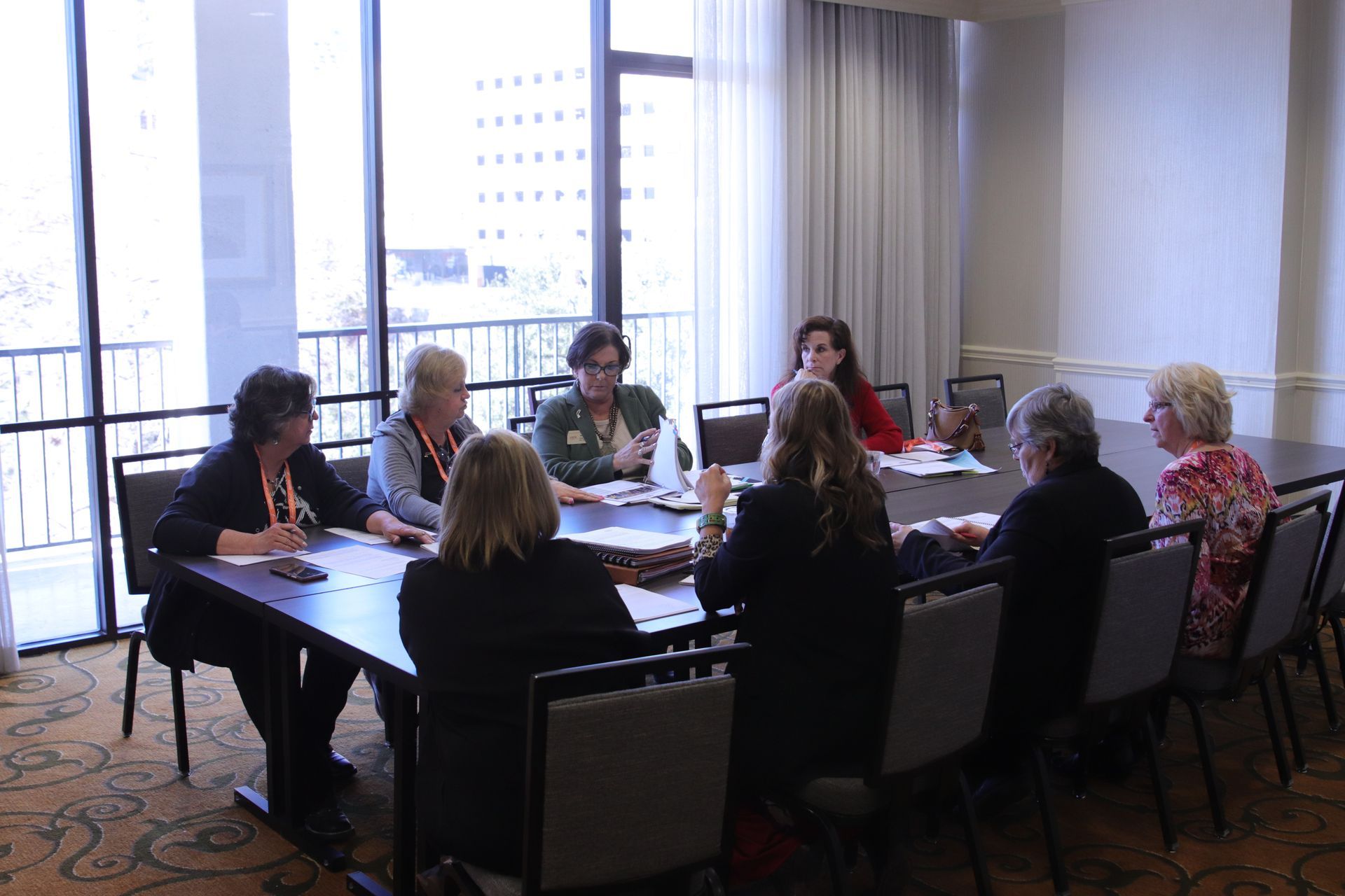 Five women smiling, posing behind illuminated 