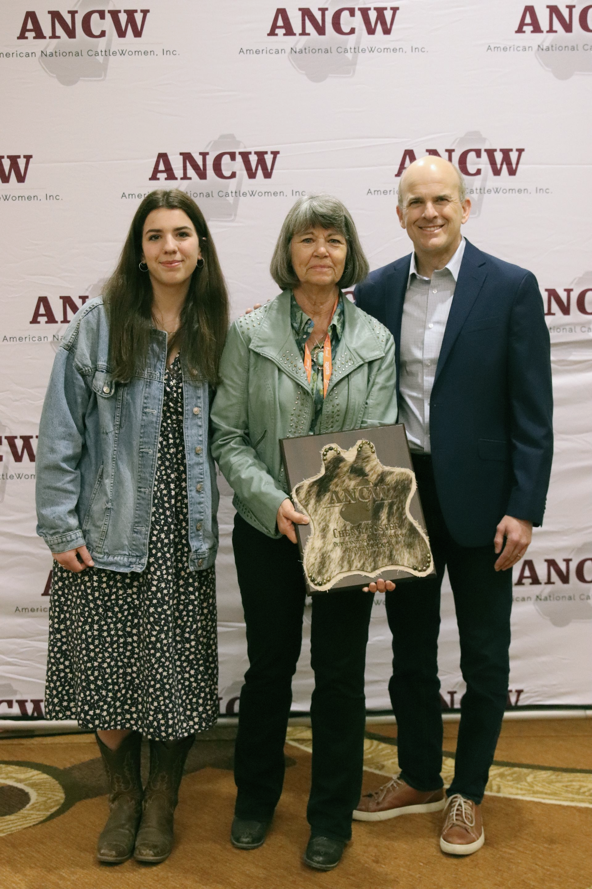 Five women smiling, posing behind illuminated 