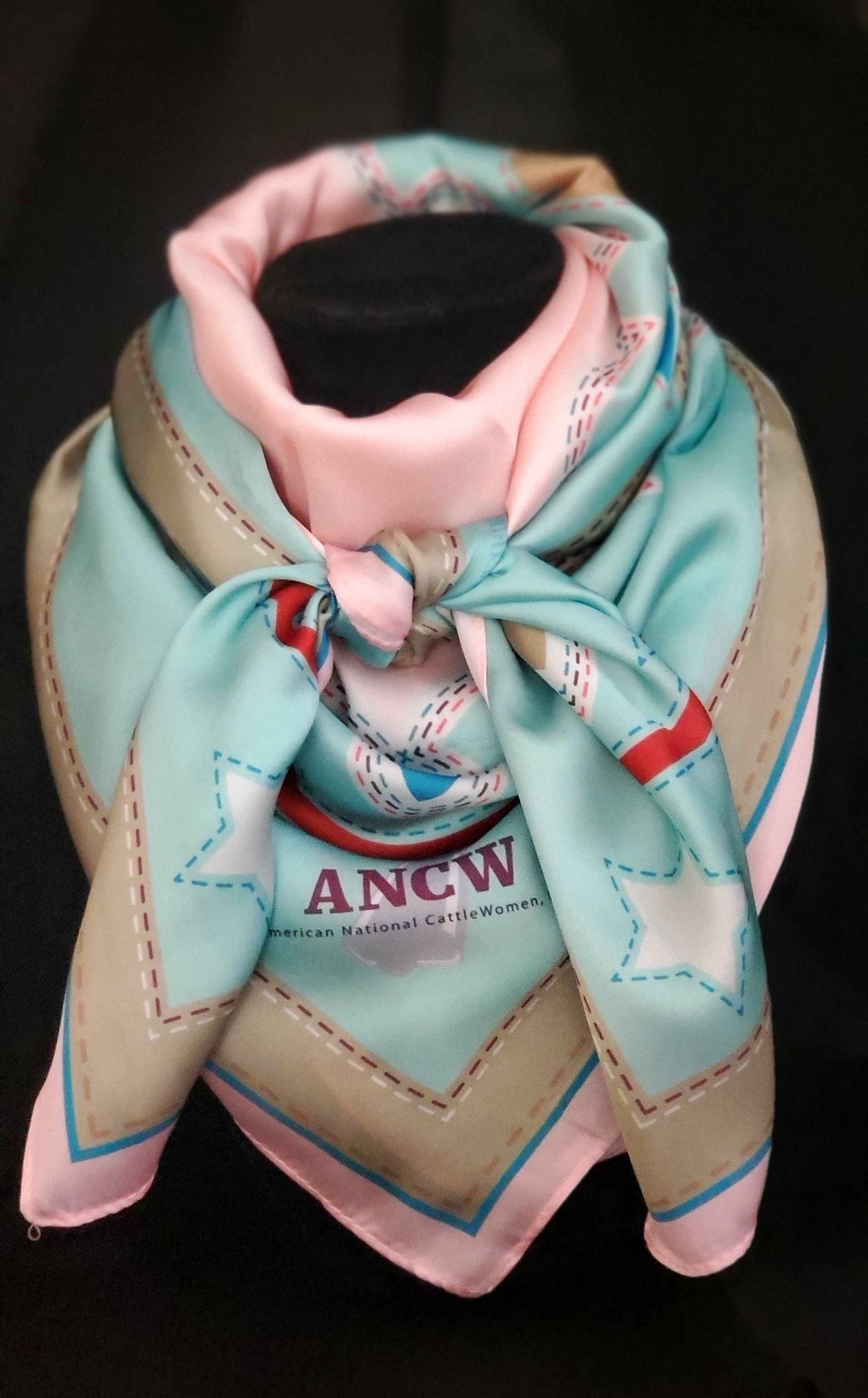 Silk scarf, light blue and pink, tied in a knot. Features stars and