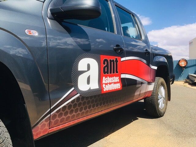 A Truck With a Sticker on the Side That Says a Ant Asbestos Solutions — Bluey's Signs in Ciccone, NT