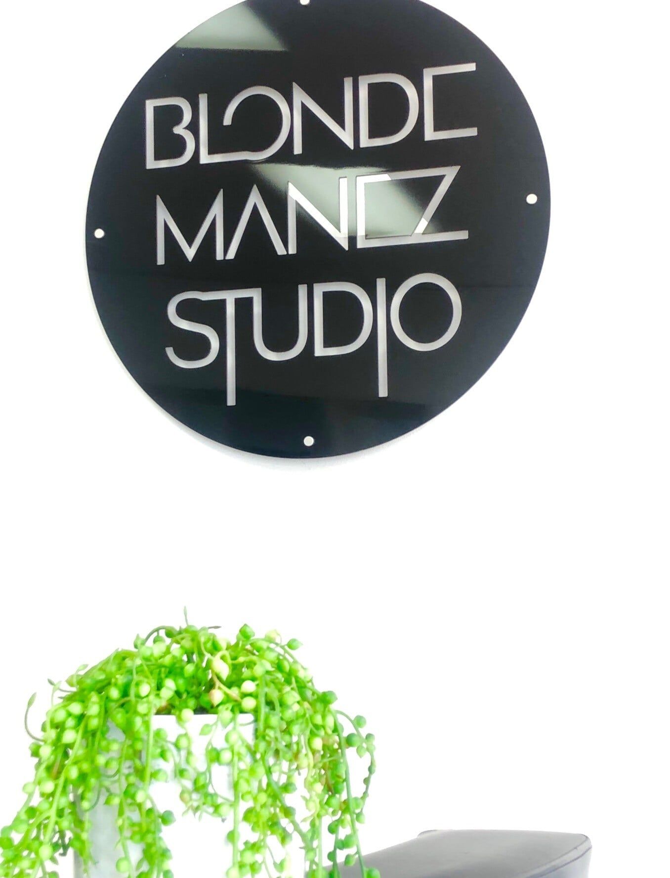 A Sign for Blonde Manz Studio Hangs Above a Potted Plant — Bluey's Signs in Ciccone, NT