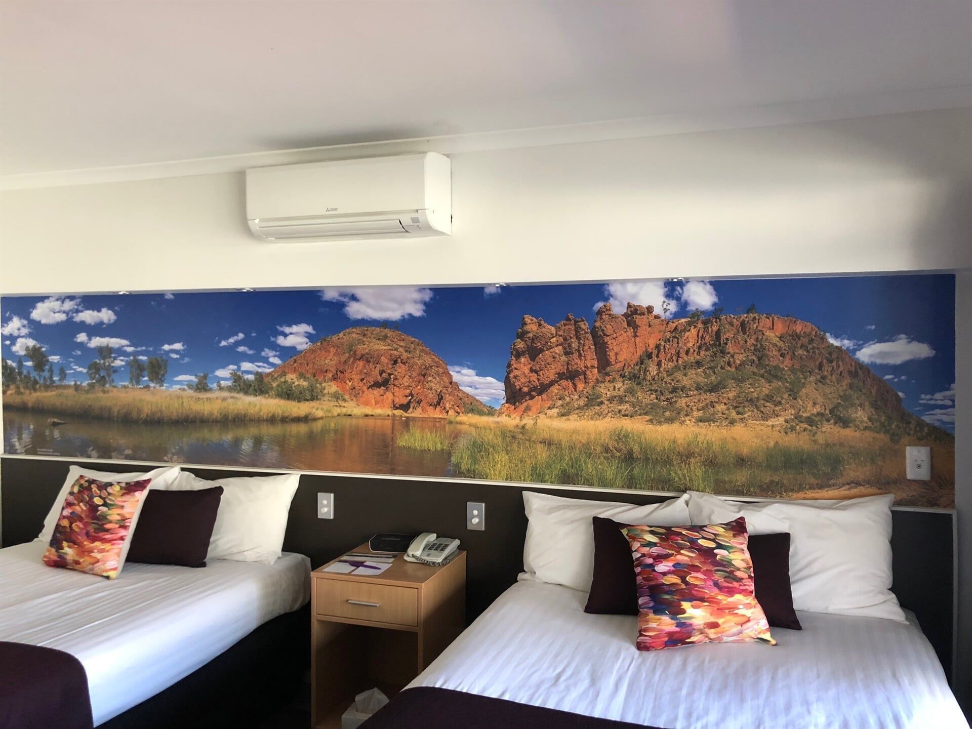 A Hotel Room With Two Beds and a Large Picture on the Wall — Bluey's Signs in Ciccone, NT