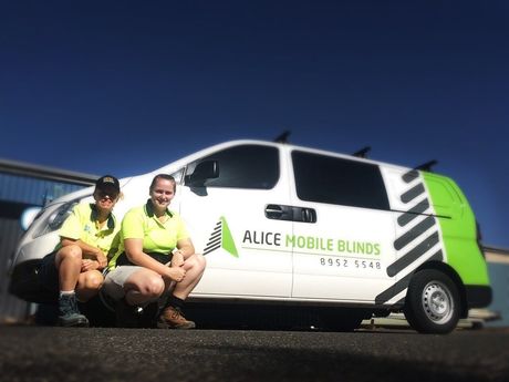 Two People Sit in Front of an Alice Mobile Blinds Van — Bluey's Signs in Ciccone, NT