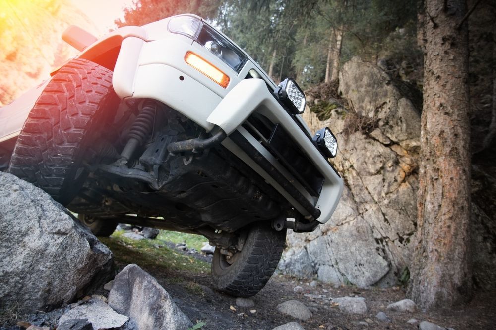 A white SUV is driving down a rocky road | Autotek New South Wales