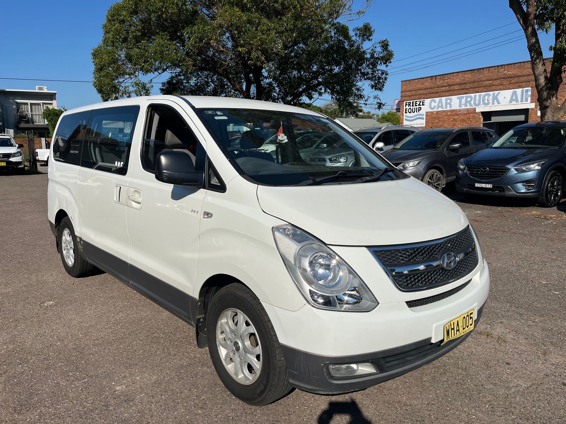 A white minivan in a parking lot | Autotek New South Wales