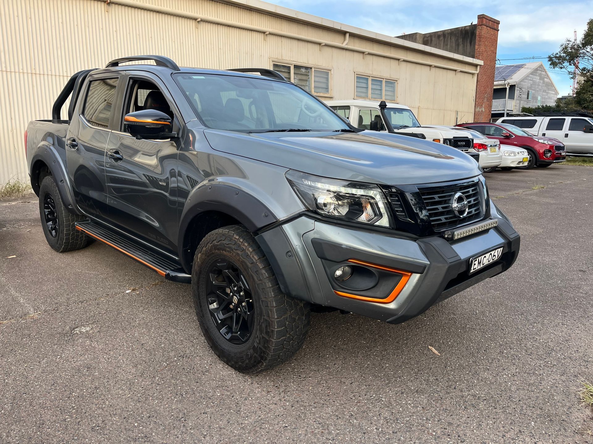 A nissan np300 pickup truck is parked in a parking lot in front of a building | Autotek New South Wales