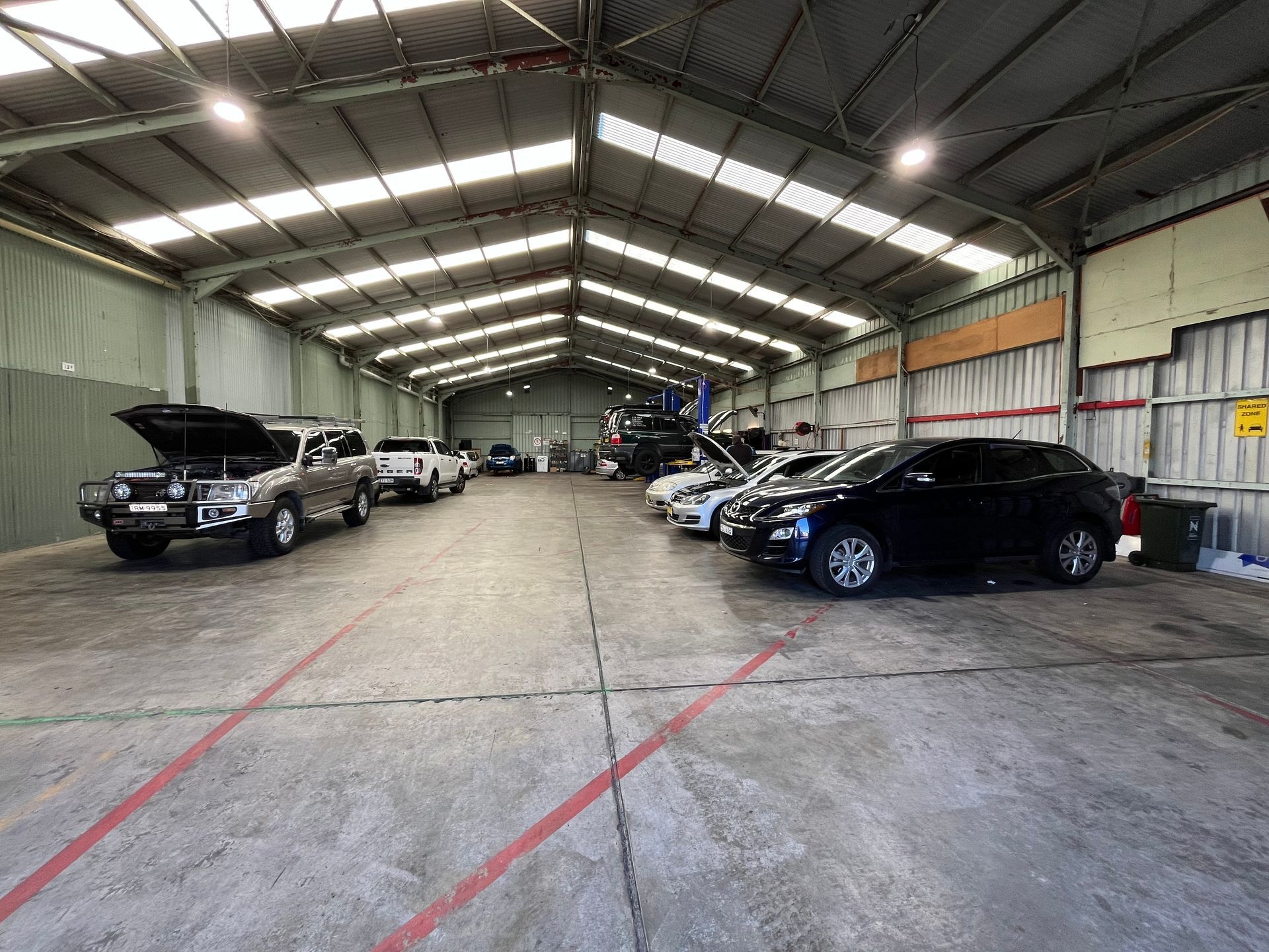 A large warehouse filled with cars parked inside of it | Autotek New South Wales