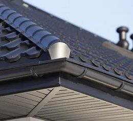 Black roof with dark gutters and a silver downspout.