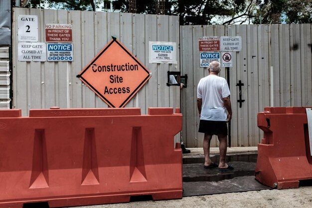 man standing against road sign