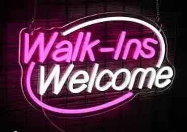 A neon sign that says `` walk ins welcome '' is hanging on a wall.