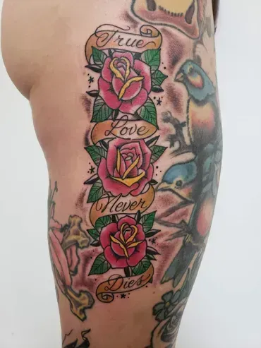 A woman has a tattoo on her leg that says `` true love never dies ''.