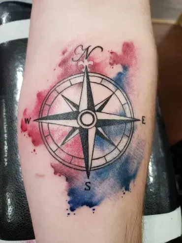 A person has a tattoo of a compass on their leg.