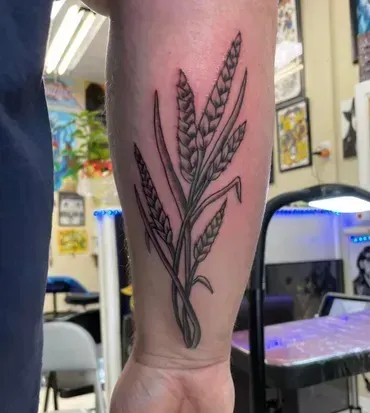 A person has a tattoo of a plant on their forearm.
