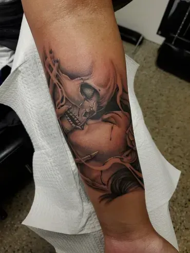 A person has a tattoo of a skull on their forearm.