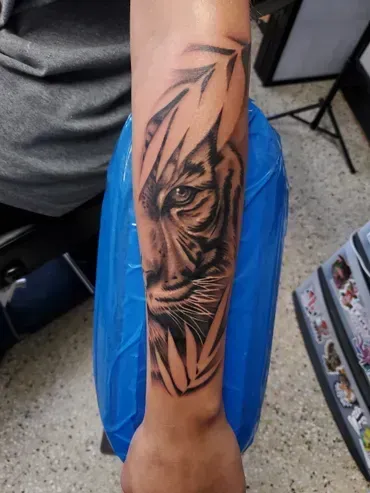 A person has a tattoo of a tiger on their forearm.
