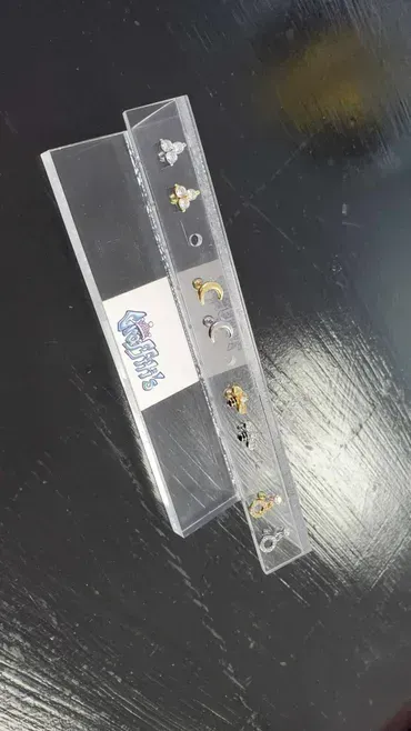 A pair of earrings sitting on top of a wooden table.