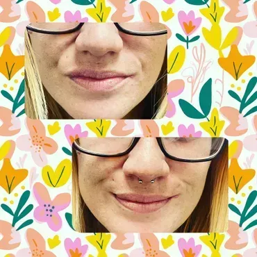 A woman is wearing glasses and a nose ring.